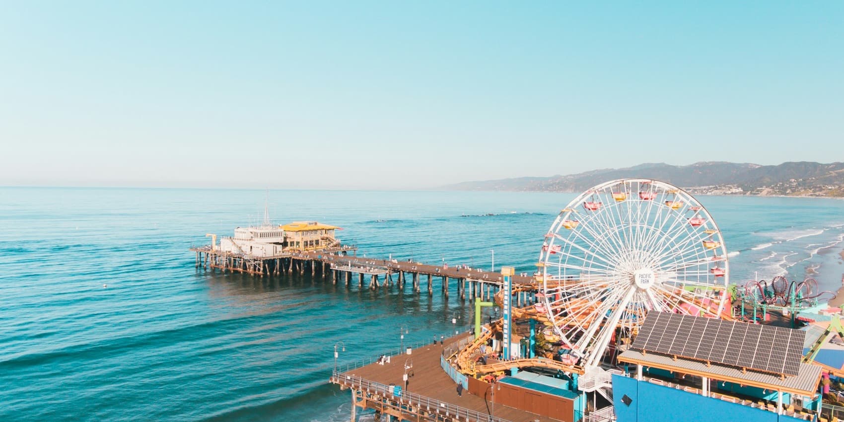 Aerial view of Santa Monica Pier with Ferris wheel and Pacific Park from above